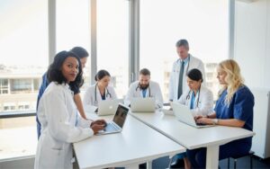 Médico acessando sistema médico em consultório para evitar erros na rotina clínica