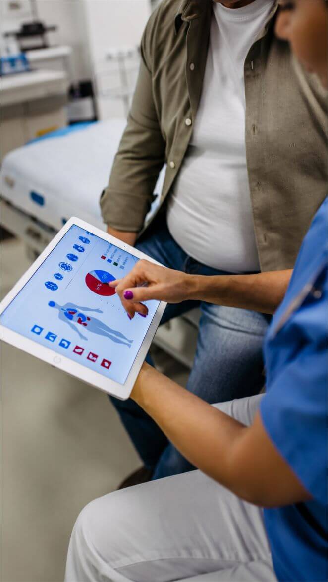 Profissional de saúde analisando dados clínicos e indicadores assistenciais em tablet para estratificação de risco e monitoramento de pacientes em operadora de saúde.